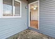 Thumbnail 42 of 64 - A grey house with a white door and window.