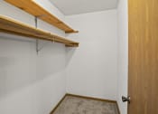 Thumbnail 23 of 26 - a walk in closet in a white room with a wooden door