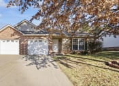 Thumbnail 1 of 15 - a brick house with a white garage door