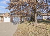 Thumbnail 2 of 15 - a house with a tree and a driveway in front of it