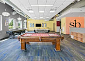 Thumbnail 16 of 56 - A room with a pool table and a bar area.