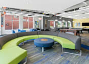 Thumbnail 12 of 56 - A modern office space with a circular seating arrangement and a long table.