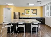 Thumbnail 23 of 56 - A kitchen with a yellow wall and a black counter.