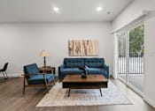 Thumbnail 17 of 38 - A living room with a blue couch and a wooden table.
