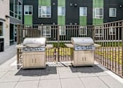 Thumbnail 19 of 56 - Two small outdoor grills are on a patio.