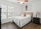 Thumbnail 30 of 38 - A bedroom with a large bed and a ceiling fan.