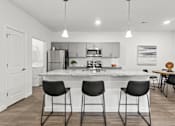 Thumbnail 27 of 38 - A kitchen with a bar area and chairs.