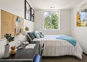 Thumbnail 30 of 56 - A bedroom with a bed, desk, and window.