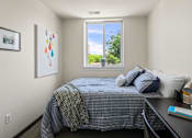 Thumbnail 31 of 56 - A bedroom with a bed, desk, and window.