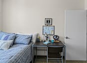 Thumbnail 42 of 56 - A bedroom with a bed, desk, and chair.