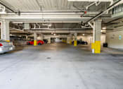 Thumbnail 55 of 56 - A parking garage with a few cars and yellow poles.