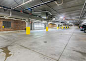 Thumbnail 53 of 56 - A parking garage with a concrete floor and yellow poles.