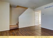 Thumbnail 8 of 35 - A living room with wooden floors and white walls.