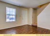 Thumbnail 6 of 35 - A living room with a wooden floor and white walls.