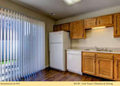 Thumbnail 10 of 35 - A kitchen with wooden cabinets and a white refrigerator.