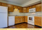 Thumbnail 7 of 35 - A kitchen with wooden cabinets and white appliances.