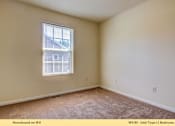 Thumbnail 9 of 35 - A bedroom with a window and carpeted floor.