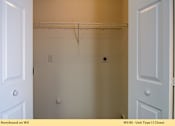 Thumbnail 13 of 35 - A white closet with a door on the left and a door on the right.