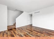 Thumbnail 35 of 35 - A living room with wooden floors and white walls.