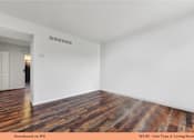 Thumbnail 31 of 35 - A living room with wooden floors and white walls.