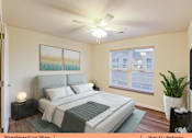 Thumbnail 2 of 31 - a bedroom with a large bed and a ceiling fan