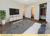 Thumbnail 12 of 31 - a bedroom with a bed and a tv