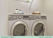 Thumbnail 25 of 31 - a white washer and dryer in a laundry room with a white counter top
