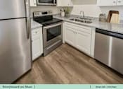 Thumbnail 22 of 31 - a kitchen with stainless steel appliances and white cabinets