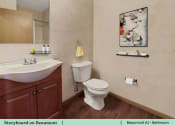 Thumbnail 8 of 30 - a bathroom with a toilet and a sink and a mirror