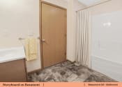 Thumbnail 14 of 30 - a bathroom with a shower and a sink and a door
