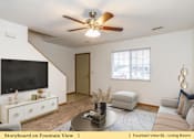 Thumbnail 14 of 27 - a living room with a ceiling fan and a tv
