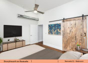Thumbnail 52 of 58 - a living room with a tv and a sliding barn door