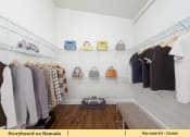Thumbnail 39 of 58 - a rack of women s clothing and bags in a closet