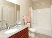 Thumbnail 10 of 23 - A bathroom with a sink, toilet, and shower.