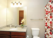 Thumbnail 12 of 23 - A bathroom with a sink, toilet, and a mirror.