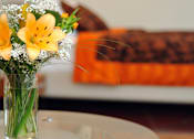 Thumbnail 8 of 23 - A vase of flowers sits on a table.