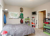 Thumbnail 20 of 23 - A bedroom with a bed, a TV, and a map on the wall.
