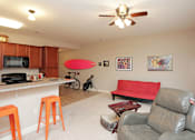 Thumbnail 18 of 23 - A living room with a red couch and a ceiling fan.