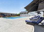 Thumbnail 25 of 32 - Swimming pool at Renaissance at Carol Stream featuring sun loungers and the building in the background in Carol Stream, IL.