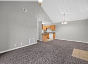 Thumbnail 6 of 18 - A room with a kitchenette and a carpeted floor.
