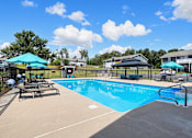 Thumbnail 26 of 27 - A large outdoor swimming pool with a slide and sun loungers.