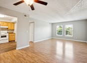 Thumbnail 7 of 21 - A room with a ceiling fan and wooden flooring.