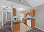 Thumbnail 3 of 18 - A kitchen with a white dishwasher and wooden cabinets.