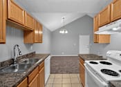 Thumbnail 4 of 18 - A kitchen with a stove, sink, and cabinets.
