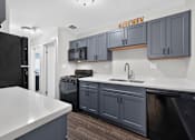 Thumbnail 2 of 32 - Kitchen at Renaissance at Carol Stream featuring a black refrigerator and matching cabinets in Carol Stream, IL.