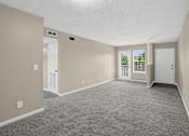 Thumbnail 3 of 27 - Spacious foyer and living room with carpeted floor and white walls at Arbours at Victoria Place in Prattville, AL