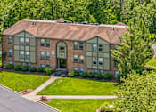 Thumbnail 20 of 21 - A large brick house with a green lawn in front.