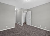 Thumbnail 8 of 18 - A room with a carpeted floor and a white door.