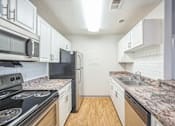 Thumbnail 2 of 20 - A kitchen with black appliances and white cabinets.