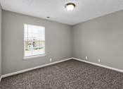 Thumbnail 9 of 18 - A room with a carpeted floor and a window.